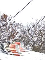 Shingles stacked on a snowy roof.
